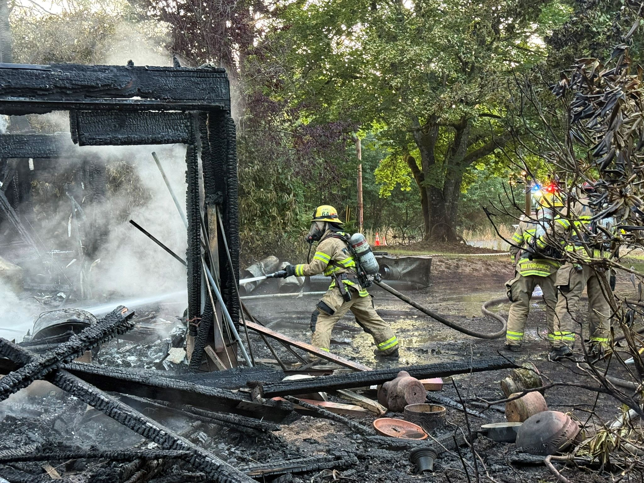 Firefighters spray water on burned home in Skyline